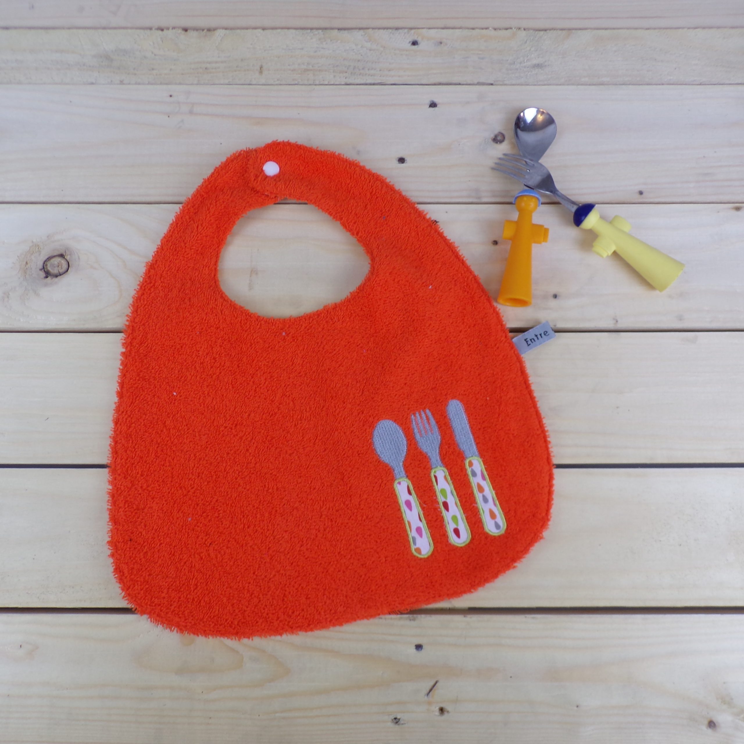 Bavoir réversible orange brodé de couverts